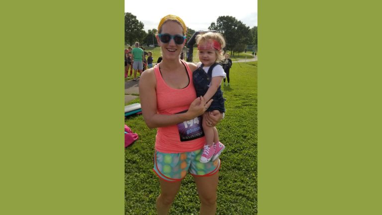 Tami holding her daughter Ada at a marathon