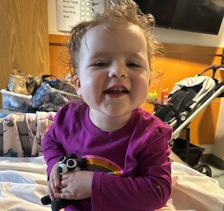Emma smiling and holding a small bear