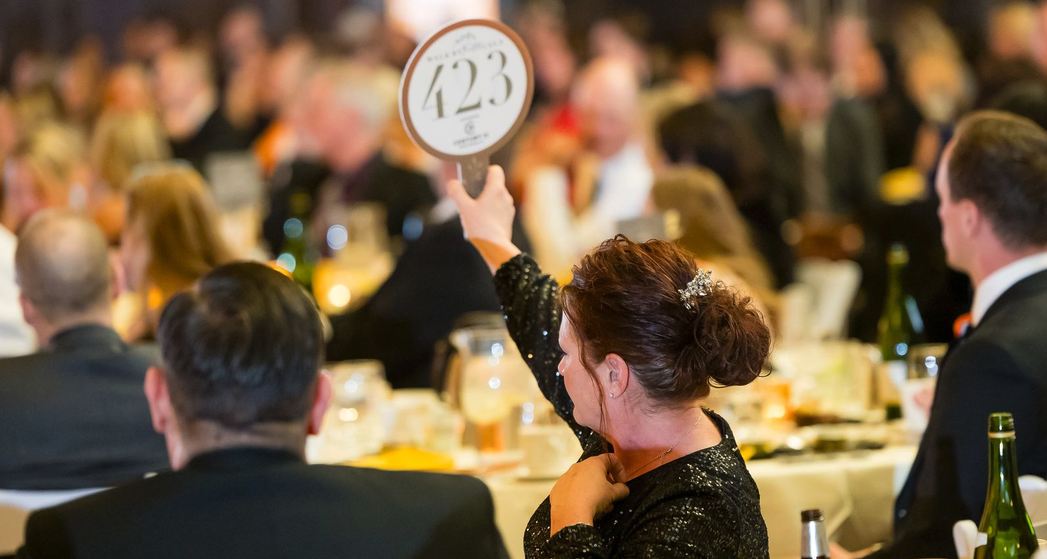 A woman bidding at an auction